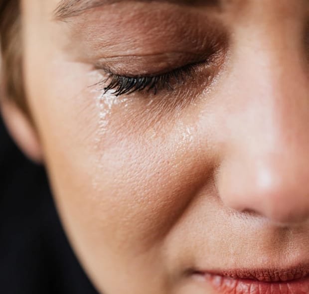 Close no rosto de uma mulher com expressão de saúde emocional abalada, indicando a necessidade de desacelerar.