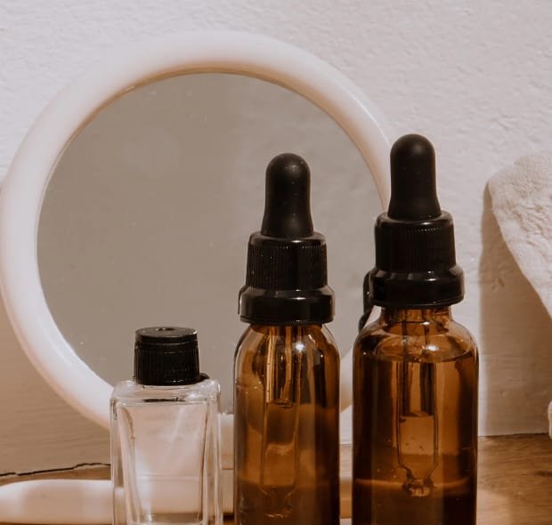 Três frascos de vidro, contendo óleos de rosa mosqueta e coco.